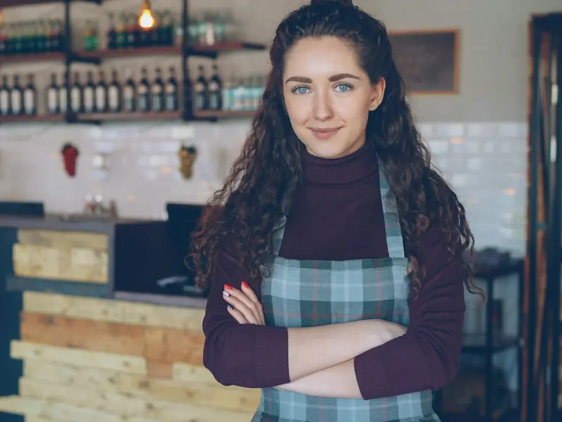 Dueña de una cafetería, de pie detrás de la barra